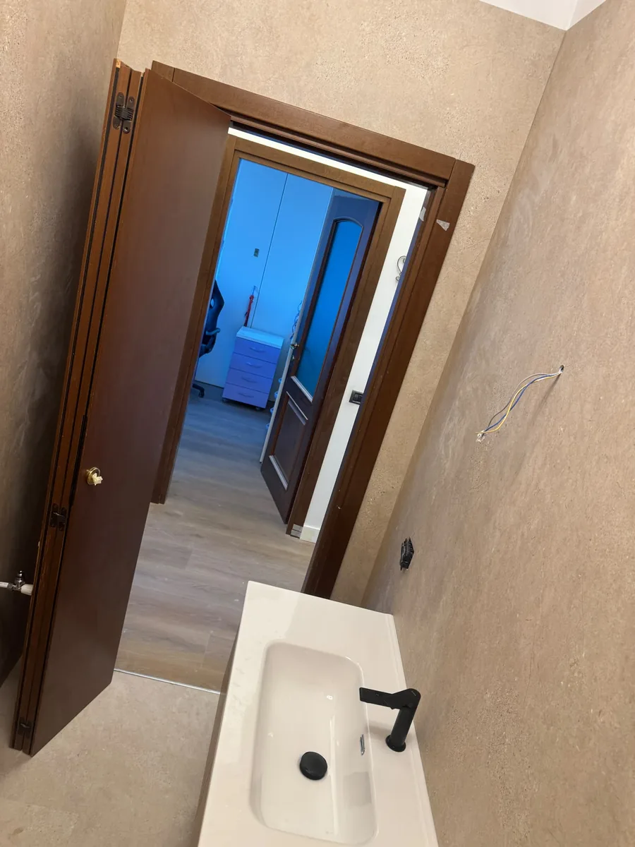 Bagno beige con lavabo squadrato e rubinetteria nera