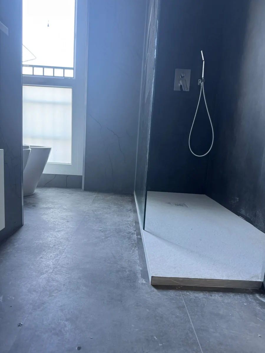 Bagno con parete antracite e doccia a filo pavimento