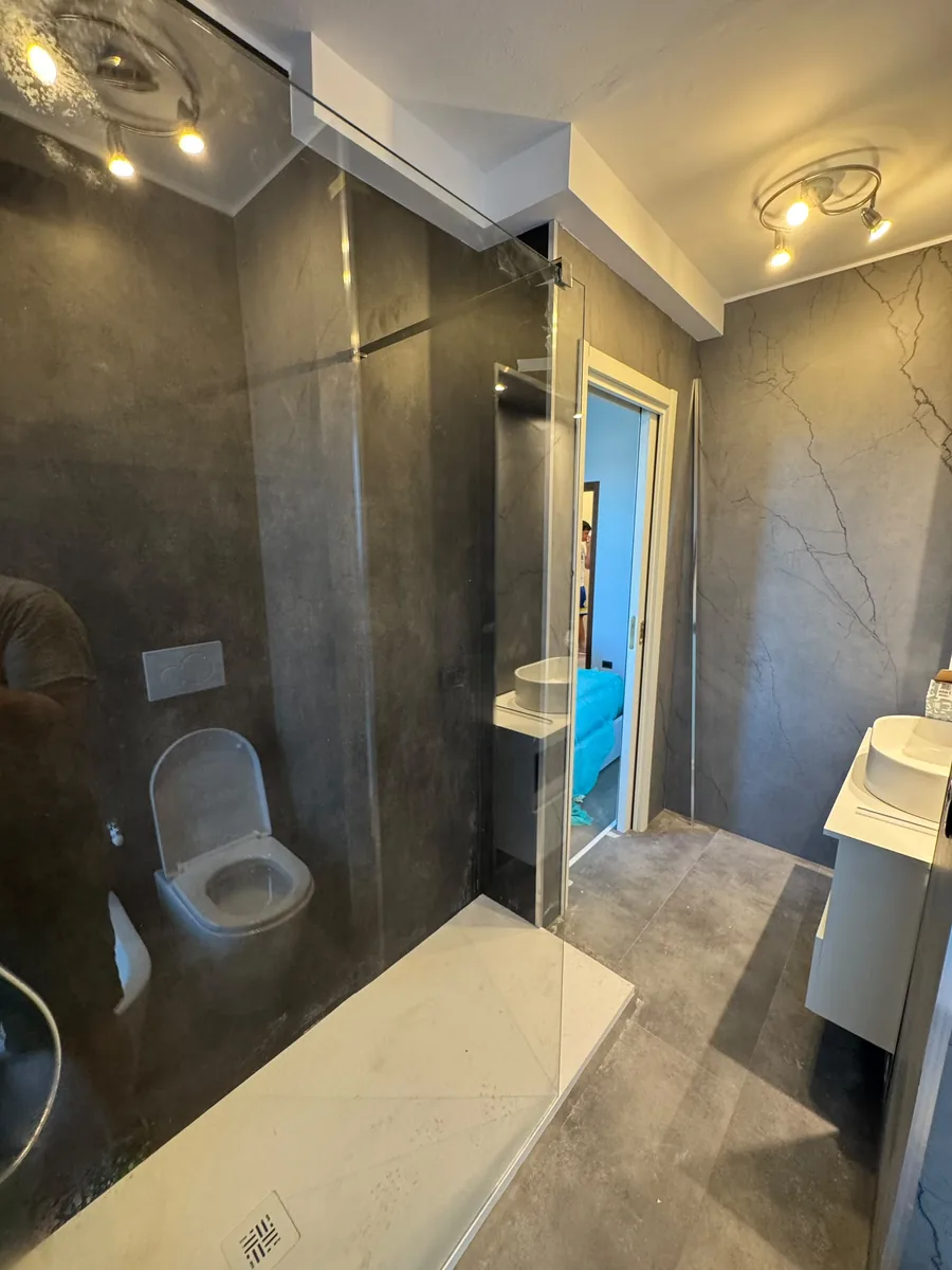 Doccia walk-in con rivestimento continuo effetto marmo scuro