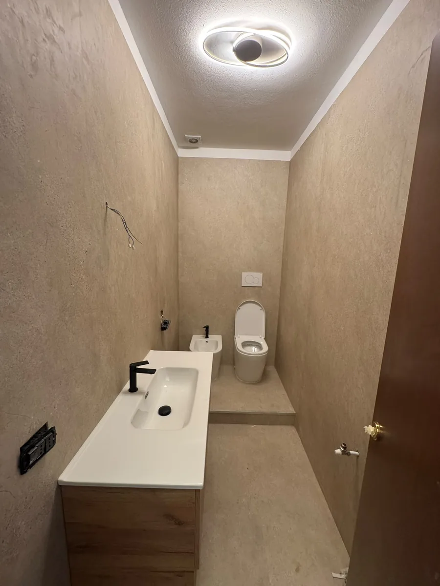 Lavabo lungo su mobile in legno e sanitari sospesi