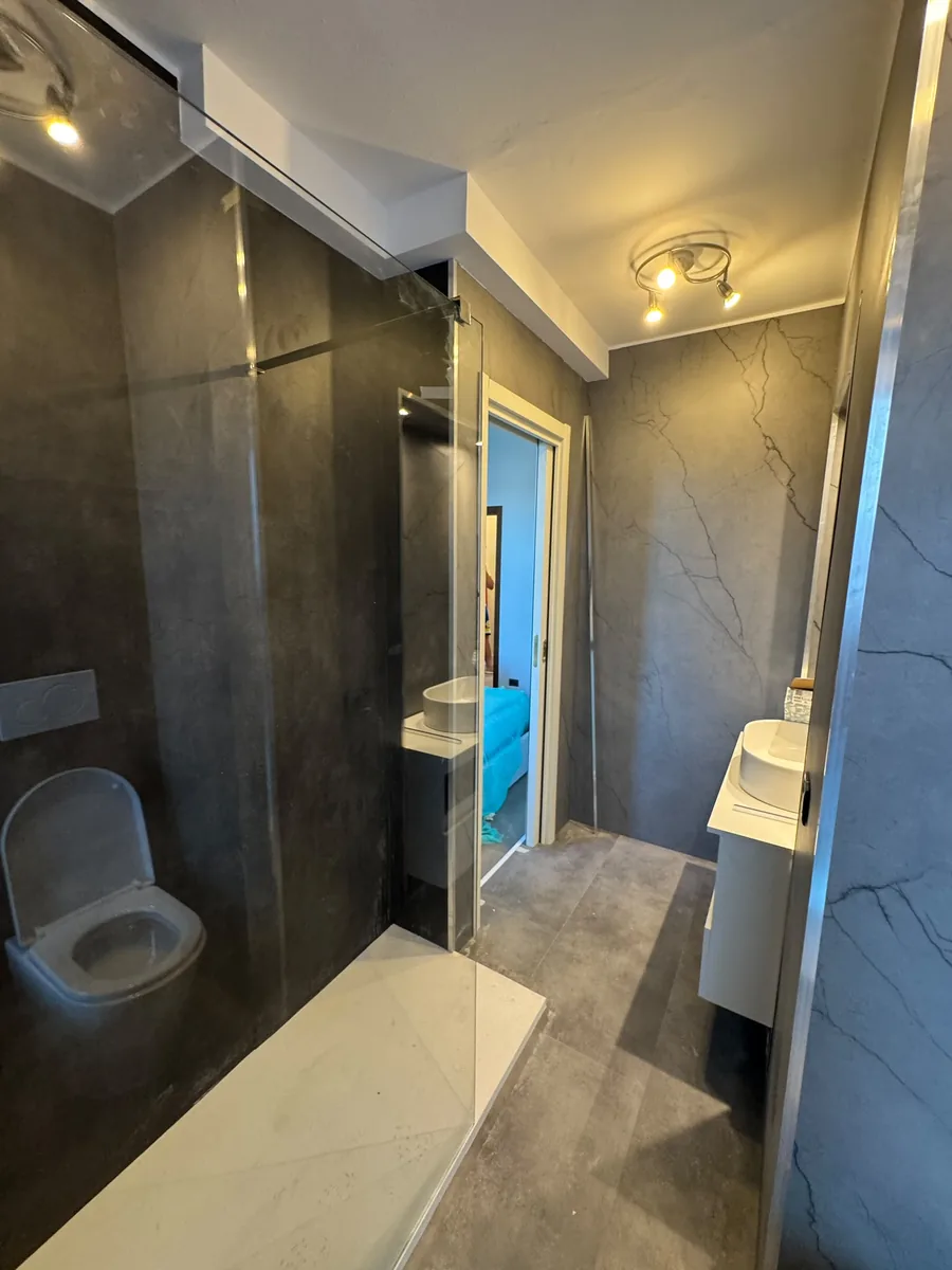 Bagno con grande specchio e doccia in cristallo
