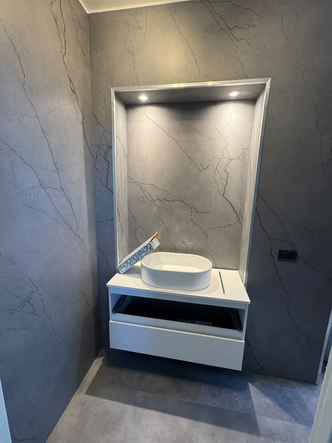 Bagno trasformato da 2EFFE Group: nicchia illuminata sopra il lavabo e mobile sospeso bianco