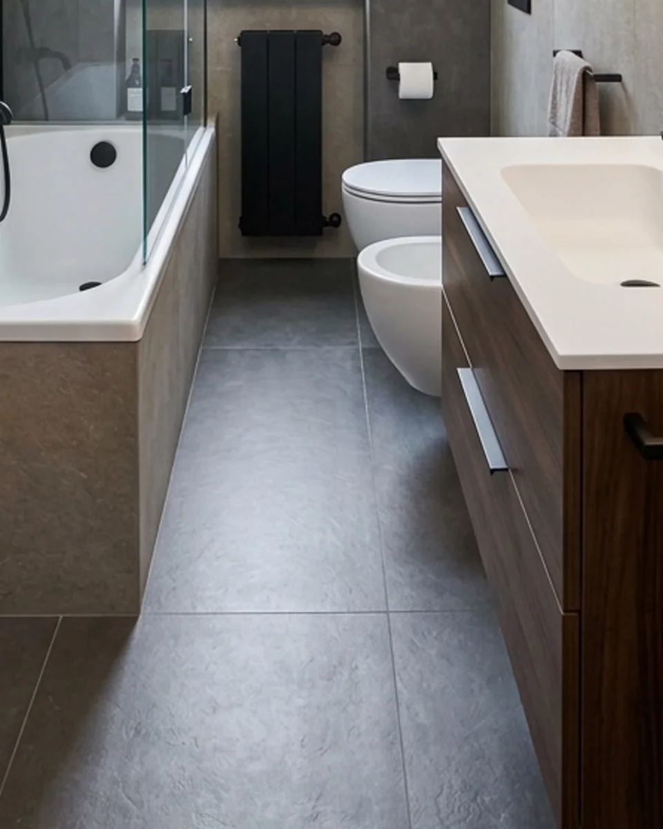 Lo stesso bagno dopo l'intervento, con rivestimento effetto pietra e mobile in legno